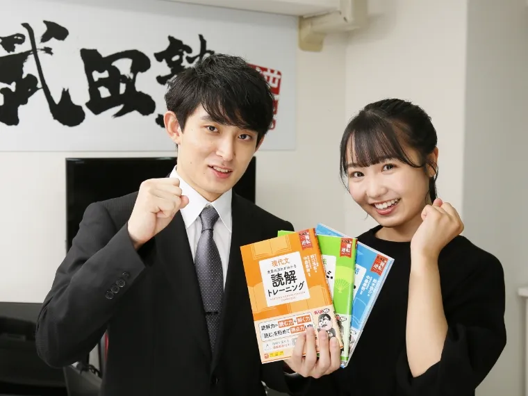 講師と生徒が参考書を手に笑顔で並んでいる様